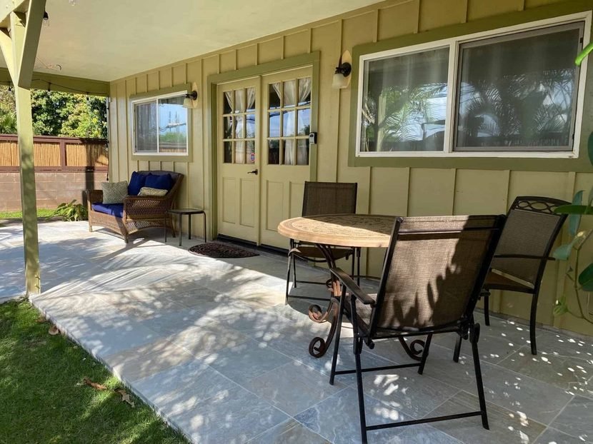 The covered lanai outside the Sunset studio with a table and chairs.