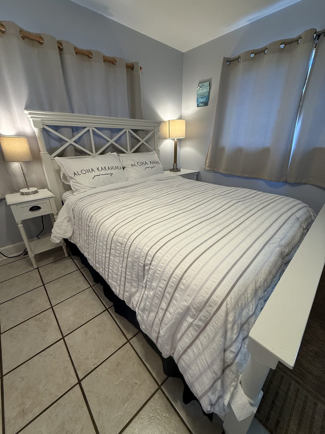 The Sunset bed from the side, with curtained windows behind it.