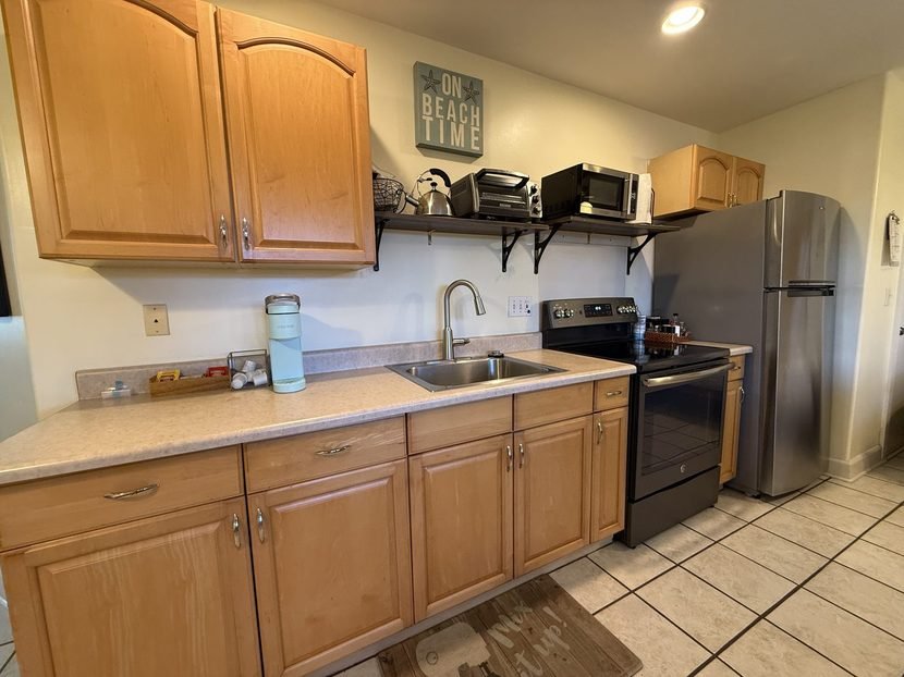 The Sunset kitchen counter and cabinets, with the range and refrigerator beyond.