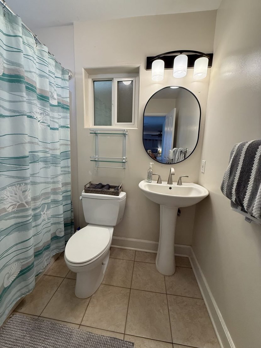 The Sunset bathroom from the doorway, with a towel on the rail beside the basin.