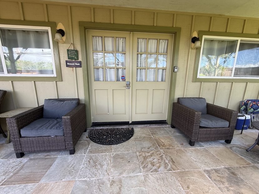 The Sunset entrance with its own doors and two wicker chairs on the tiled lanai.