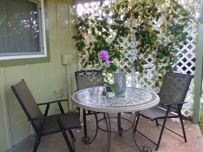 The bistro table on the Sunset lanai with a lattice screen and flowers.